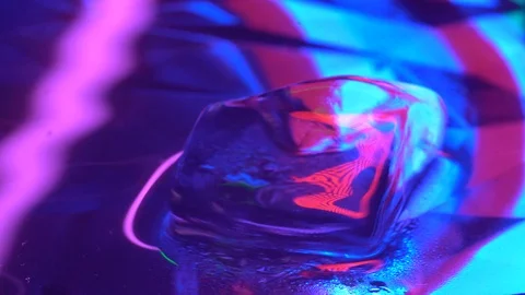 Pink cube of ice rotating in water Stock Footage 106828599