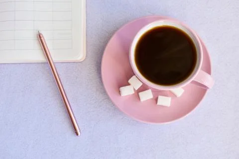 Pink cup black of coffee, notebook, pen. Overhead view. Isolated on white. Flat Stock Photos