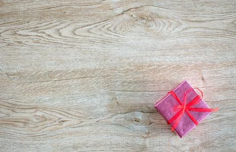 The pink current box a small has red ribbons placed on an old wooden table .. Stock Photos