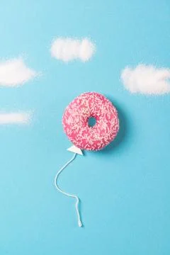 Pink donut on blue background, creative food minimalism, balloon donut Stock Photos