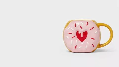 Pink donut mug on a plain background for drink and gift ideas Fotos de archivo