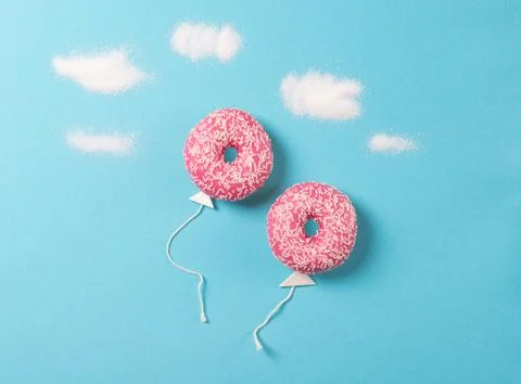 Pink donuts on blue background, creative food, donut in a shape of balloon Stock Photos