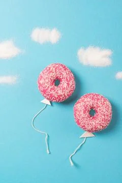 Pink donuts on blue background, creative food minimalism, balloon donut Stock Photos
