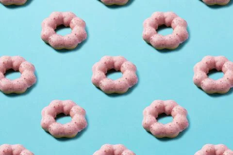 Pink donuts lined up regularly on a blue background Stock Photos