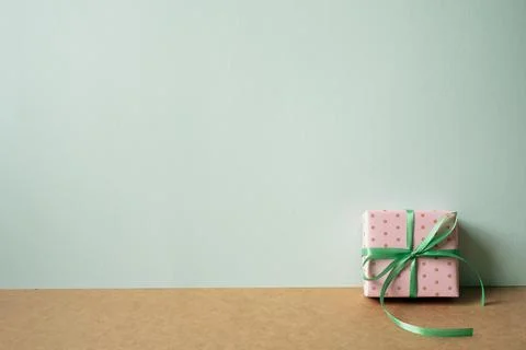 Pink dot pattern gift box on brown table. mint green wall background Stock Photos