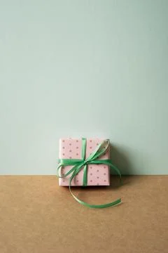 Pink dot pattern gift box on brown table. mint green wall background Stock Photos