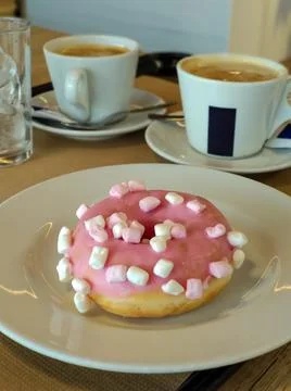Pink doughnut with two coffees Stock-Fotos