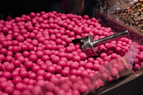 Pink dragee candy balls arranged as a vibrant sweet background texture. Stock Photos