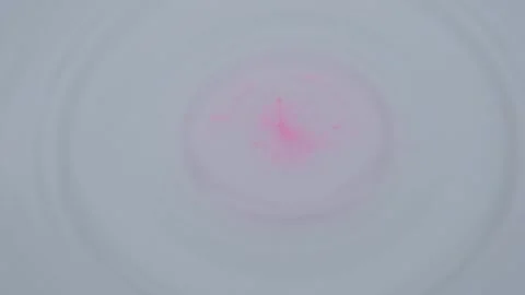 Pink drop of ink falling on white liquid Stock Footage 148925026