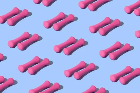 Pink dumbbell on a blue background. Stock Photos