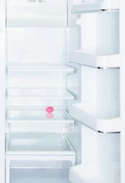 Pink Easter egg in open, empty white refrigerator Stock Photos