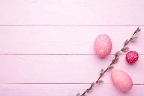 Pink easter eggs and willow branches on pink wooden background Stock Photos