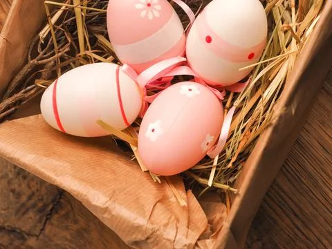 Pink Easter eggs in a cardboard box on a rustic wooden table background 写真素材