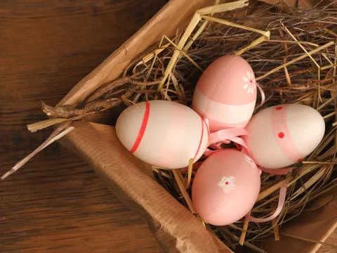 Pink Easter eggs in a cardboard box on a rustic wooden table background 写真素材