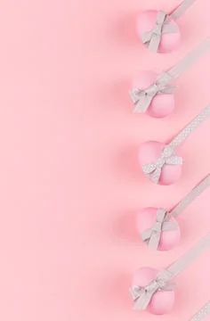 Pink easter eggs with grey bows and ribbons as border on pastel pink backgrou Stock Photos