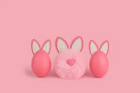 Pink Easter fluffy bunny and two eggs with ears on a pink background. Stock Photos
