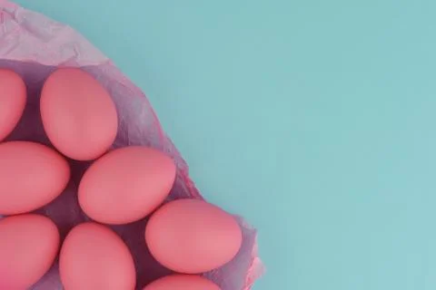 Pink easter painted eggs on crumpled wrapping paper. Blue background. Stock Photos