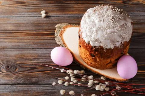 Pink  eggs, willow twigs, Easter cake with icing on a dark wooden background  Stock Photos