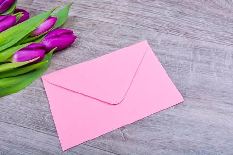 Pink envelope with tulips on a table Foto stock