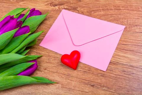 Pink envelope with tulips on a table 스톡 사진