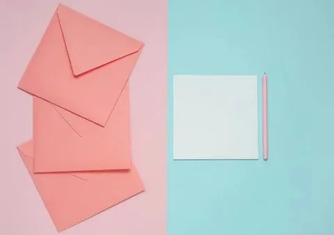 Pink envelopes and notepad with pen on pastel background Stock Photos