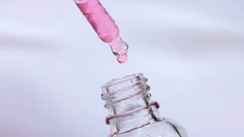 Pink face serum for moisturizing and making facial massage drops from pipette Stock Footage 264096181