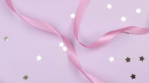 Pink festive delicate pastel background with satin ribbons and golden stars Stock Footage 221713495
