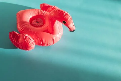 Pink Flamingo Shaped Pool Float on Turquoise Water under Sunlight. Front view Fotos de archivo