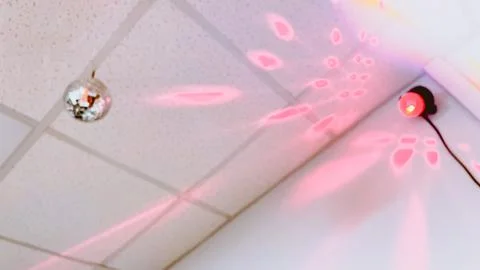 Pink flash lights coming from stroboscope on ceiling. Disco ball. Party Stock Photos