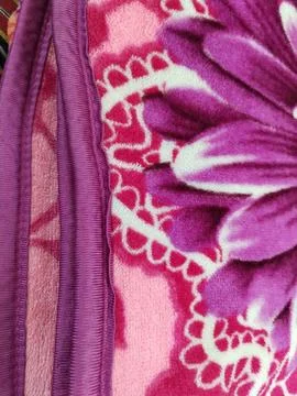 Pink floral pattern soft blanket with purple trim Foto stock