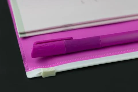 A pink folder a pen and a stack of notebooks Stock Photos