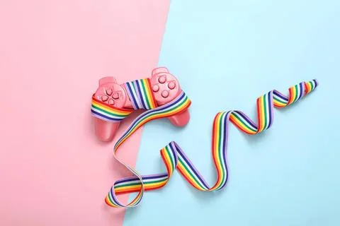 Pink game controller with rainbow ribbon on pastel background Stock Photos