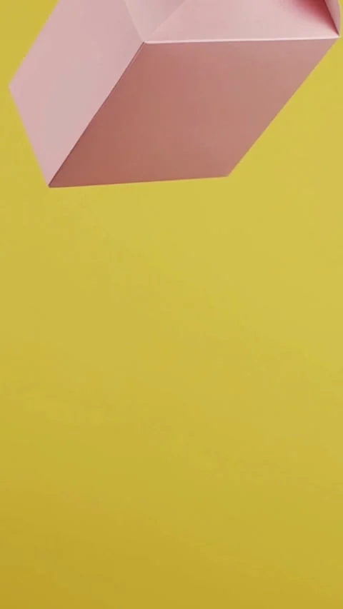 Pink gift box falling against solid bright yellow background Stock Footage 331781132