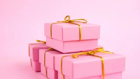 Pink Gift Boxes Stacked with Golden Ribbons on Pink Background - Celebration Stock Footage 333410027