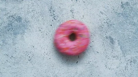 Pink glazed donut falling on gray background. Stock Footage 129748644
