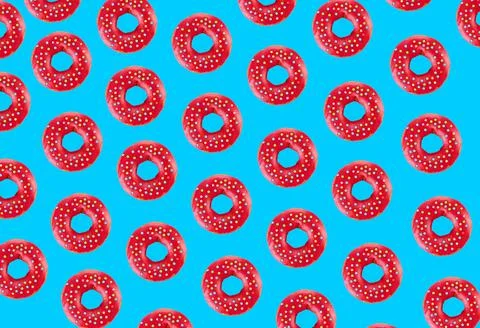 Pink glazed donut pattern on blue pastel background. Creative concept. 库存照片