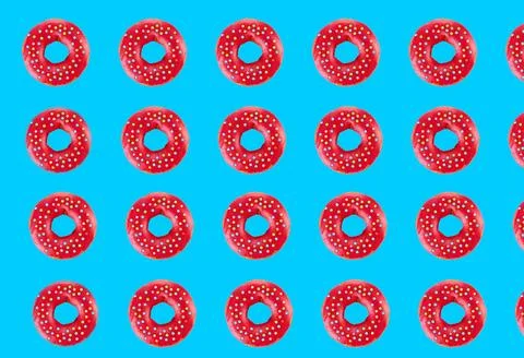Pink glazed donut pattern on blue pastel background. Creative concept. Stock Photos
