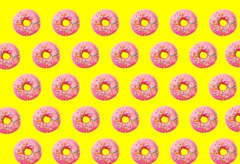Pink glazed donut pattern on yellow pastel background. Creative concept. Stock Photos