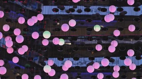 Pink glowing spheres creating abstract light art installation at night Stock Photos