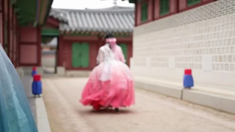 Pink hanbok dancer moves gracefully through ancient courtyard Vídeos de archivo 339172959