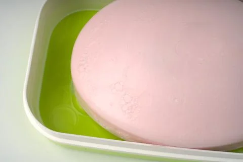 Pink hand and face soap in a soap dish on a white background. Stock Photos