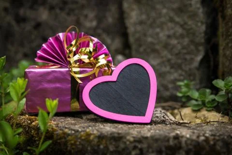 Pink heart and present on a vintage rockery Foto stock