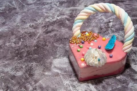 Pink heart shape cake on a gray marble background with a lot of small colorful Stock Photos