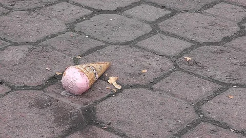 Pink ice cream falling onto the pavement and breaking into pieces Stock Footage 106993653