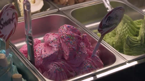 Pink ice cream with sprinkles inside metal container, bright dessert color Stock Footage 321817997