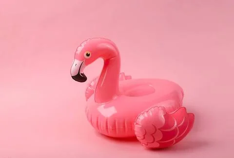 Pink inflatable flamingo pool float on pink background Stock Photos