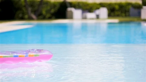 Pink inflatable mattress floating on water surface in swimming pool Stock Footage 112585437