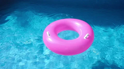 Pink inflatable ring in the swimming pool. Refreshing blue water. Nobody Stock Footage 160549123