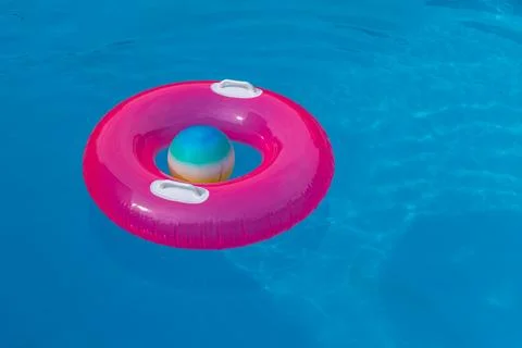 Pink Inflatable Swim Ring in Empty Pool on Hot Summer Day for Childrens Wat.. Stock Photos
