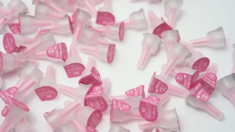 Pink insulin pen needles falling in slow motion Video stock 335025697